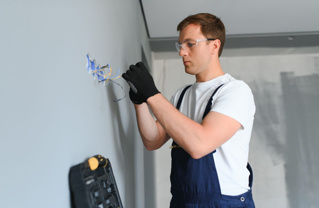 Electrician at work on switches and sockets of a residential electrical system.